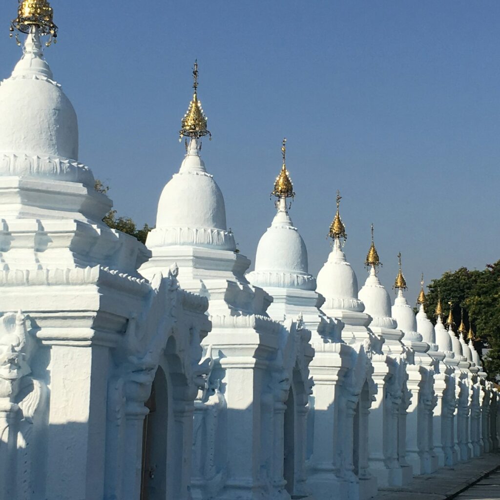 a row of white buildings with gold spires