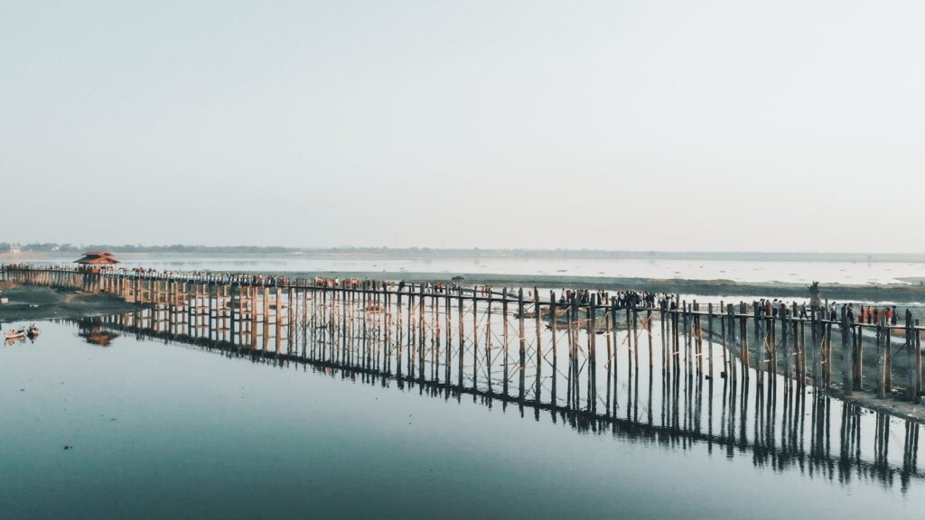 brown wooden dock on sea under white sky during daytime