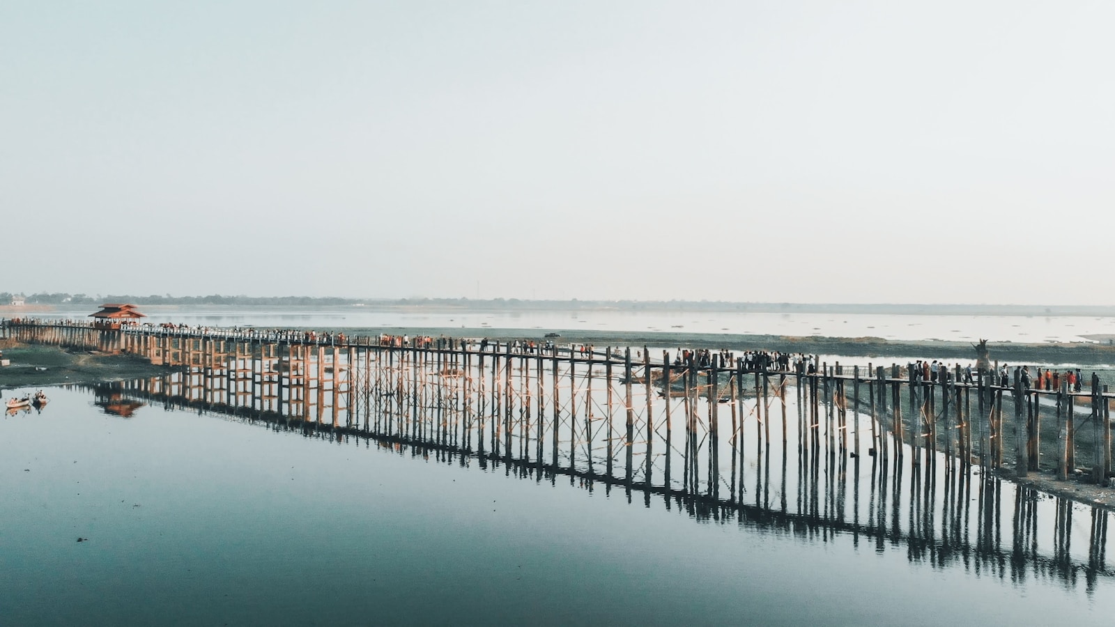 brown wooden dock on sea under white sky during daytime